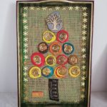 A tray, decorated with bits of old melted plastic, in the shape of a christmas tree, recycled artwork by Anne Bickley